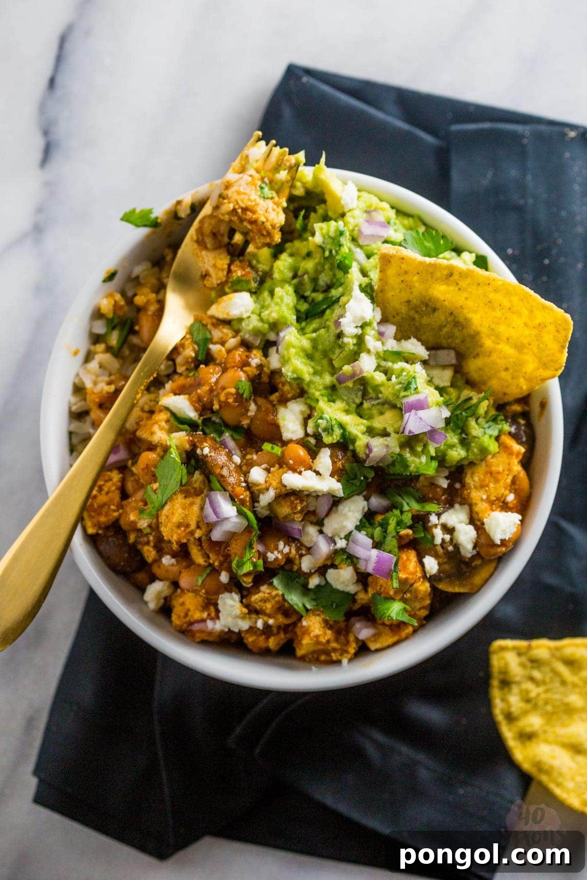 Close-up of a vibrant Tofu Sofritas Bowl with rice, guacamole, and fresh toppings. | 40 Aprons