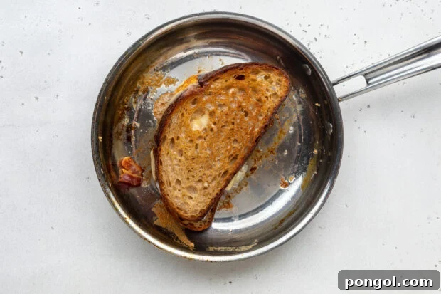 The Ultimate Breakfast Stack 8 Fried egg sandwich grilling in a large skillet, bread toasted golden brown and cheese melted.