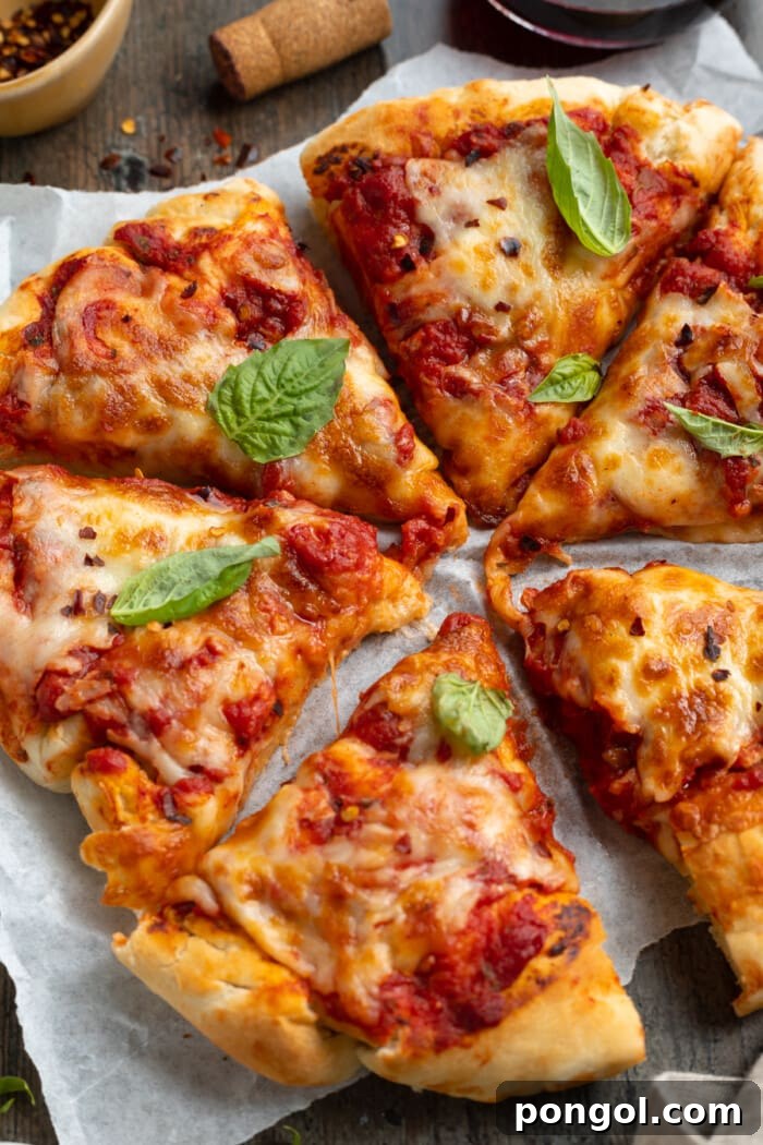 Ultimate Air Fryer Pizza 2 Close-up, angled view of soft and fluffy air fryer pizza on a white plate, showcasing its golden-brown crust and melted cheese.