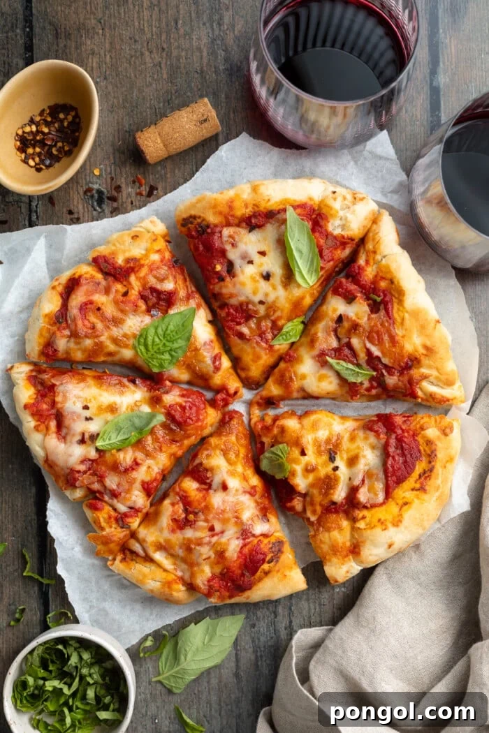 Ultimate Air Fryer Pizza 3 Overhead view of a round air fryer pizza sliced into 6 slices and topped with cheese and pizza sauce, fresh from the air fryer.