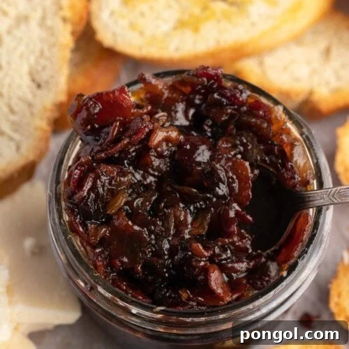Overhead view of a jar of bacon jam surrounded by slices of crisp bread.
