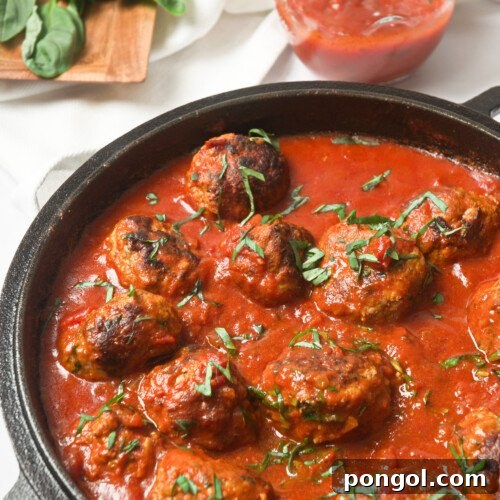 Wholesome Whole30 Meatballs in Rich Marinara 4 Whole30 Italian meatballs with marinara sauce in a cast-iron skillet, beautifully plated.