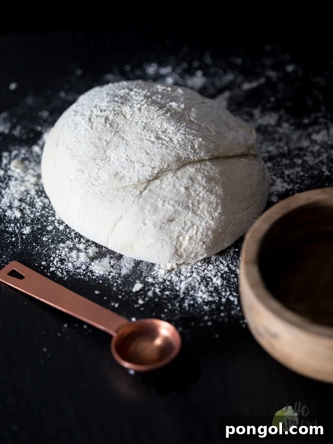 Finished Perfect Food Processor Pizza Dough, topped with sauce and cheese, ready for baking. This quick and easy homemade pizza crust promises a delicious family meal.