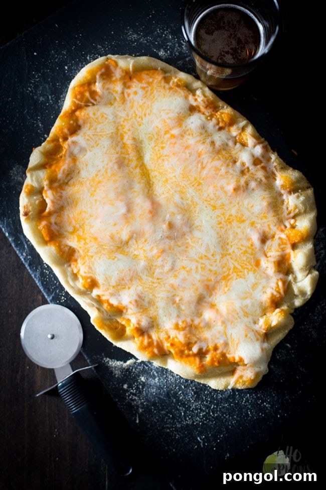 Preparing the pizza dough on parchment paper for grilling, ensuring a thin, even crust.