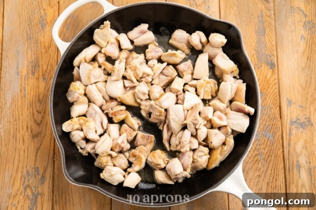 Sticky Bourbon Glazed Chicken 7 Chopped chicken thigh pieces in large skillet with neutral oil.