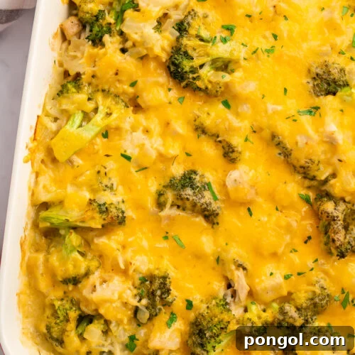 Overhead view of a white rectangular casserole dish angled from the top right corner of the image. Dish contains a baked chicken broccoli rice casserole.