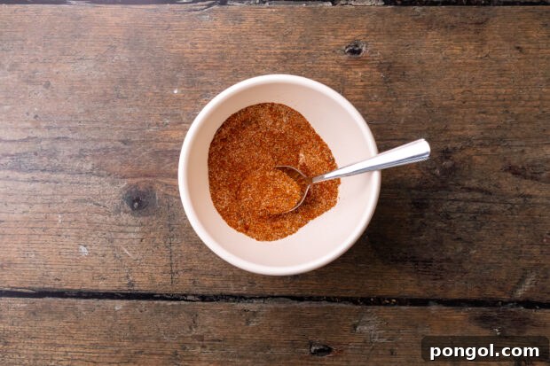 Overhead view of shredded beef taco seasoning in a small white bowl.