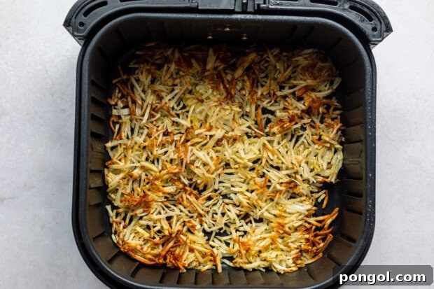 Golden Air Fryer Hashbrowns with Fiery Chipotle Ketchup 7 Overhead view of air fryer hashbrowns in an air fryer basket.