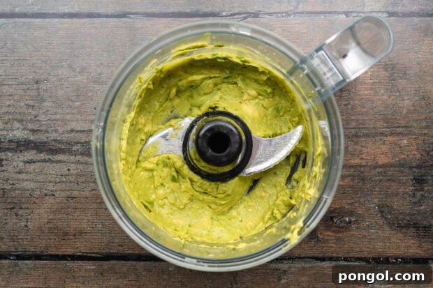 Tangy Beet Tacos 7 Overhead view of creamy guacamole in a food processor bowl, ready to be served.