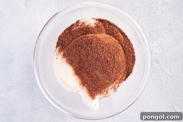 Overhead view of Whole30 mayo and chipotle chili powder in a small glass mixing bowl.