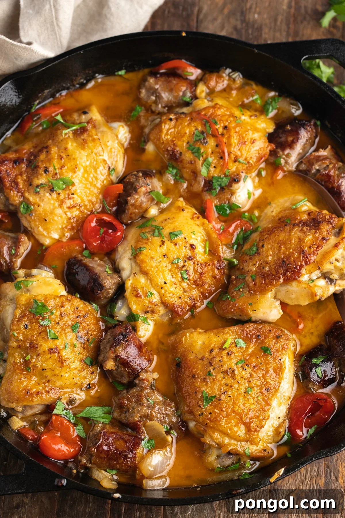 Zesty Rustic Chicken Skillet 3 Zoomed out overhead view of chicken scarpariello in a large black cast-iron skillet.