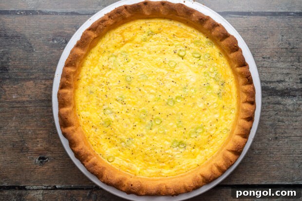 Overhead view of a fully-baked keto quiche in a pie plate, shot from overhead.