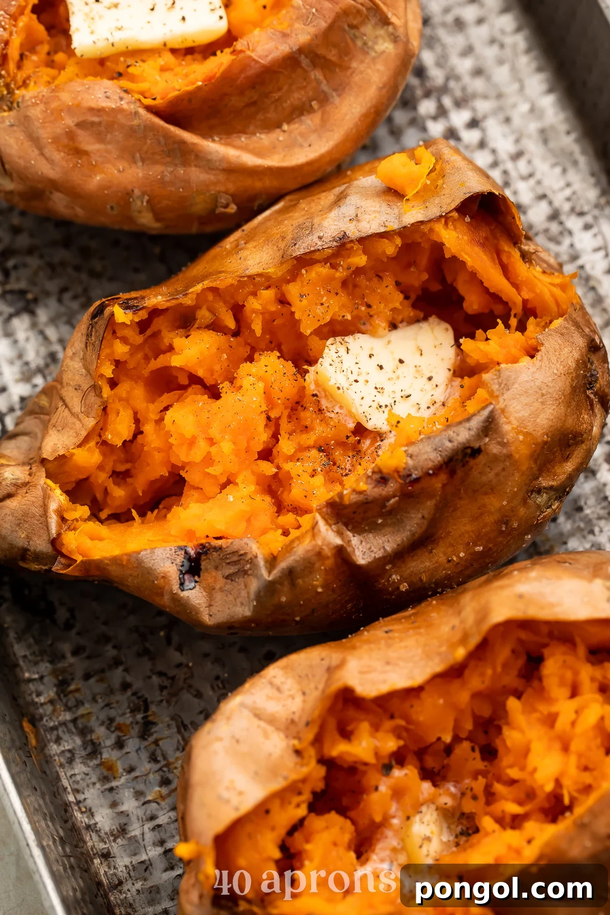 Crispy Air Fryer Sweet Potatoes 2 Overhead view of a row of cut-open air fryer sweet potatoes angling from the top left corner of the image to the bottom right corner.
