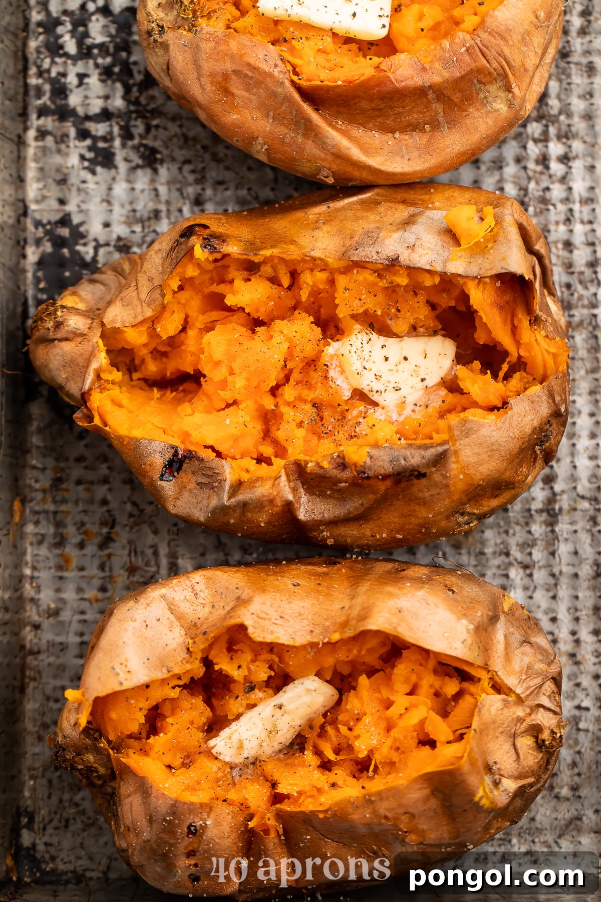 Crispy Air Fryer Sweet Potatoes 3 Overhead view of a vertical row of cut-open sweet potatoes on a sheet of parchment paper.