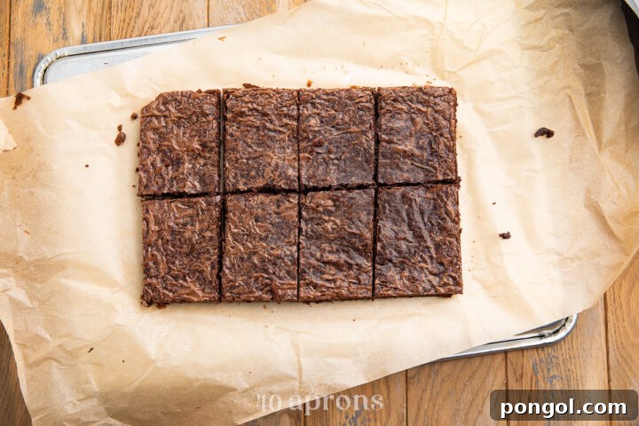 Overhead view of a sheet of chocolate brownies, cut into 8 rectangles before being decorated.