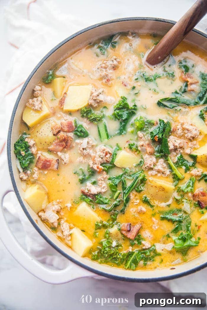 A large pot of Whole30 healthy zuppa toscana bubbling gently, filled with delicious ingredients