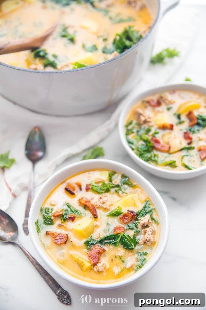 Two bowls of Whole30 healthy zuppa toscana recipe with a large pot in the background