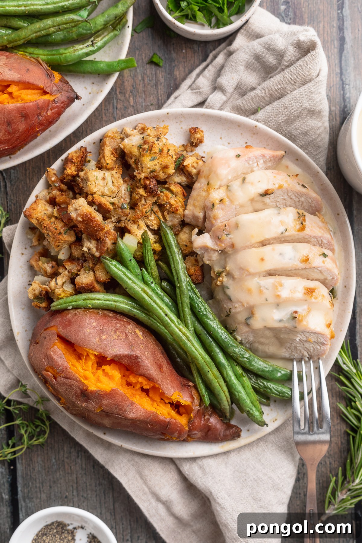 Effortless Holiday Feast 3 Overhead view of a perfectly plated one-pan holiday meal on a round dinner plate, beautifully showcasing sliced turkey, a generous portion of stuffing, tender green beans, and fluffy sweet potatoes, ready to be enjoyed.