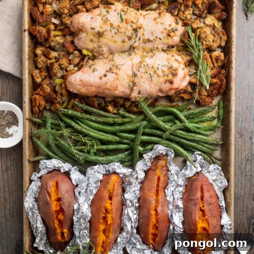 Effortless Holiday Feast 4 Overhead view of a sheet pan filled with vibrant green beans, golden-brown turkey, foil-wrapped sweet potatoes, and savory stuffing, ready for a delicious holiday meal.