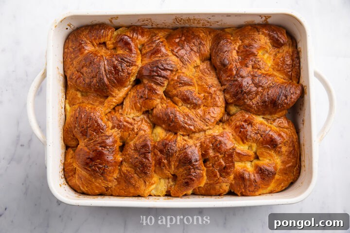 Overhead view of a baked croissant french toast casserole in a large rectangular casserole dish.