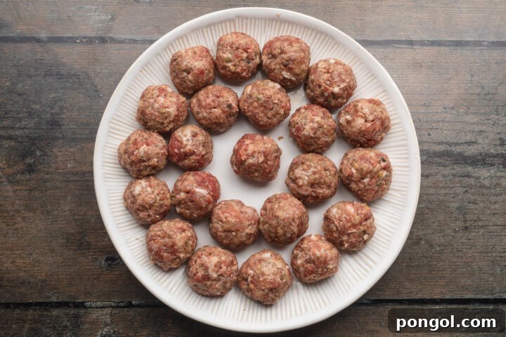 Overhead view of rolled meatballs on a round plate.