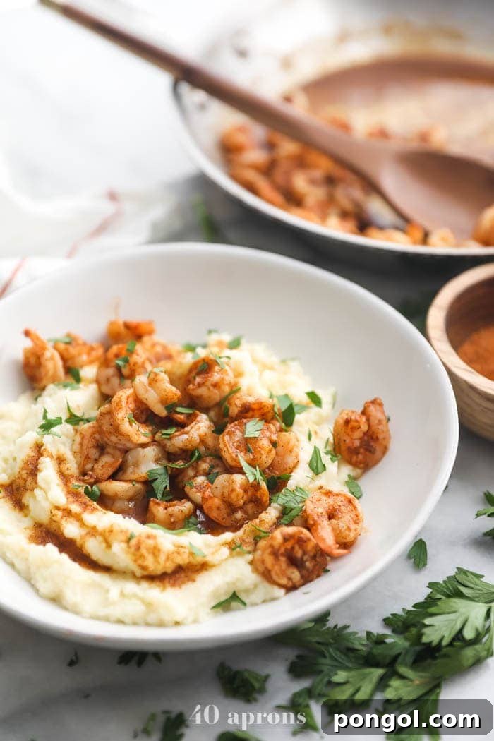 Whole30 healthy shrimp and grits in a bowl with skillet in background