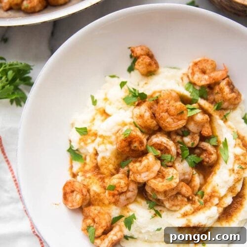 Whole30 healthy shrimp and grits in a bowl with skillet to the side
