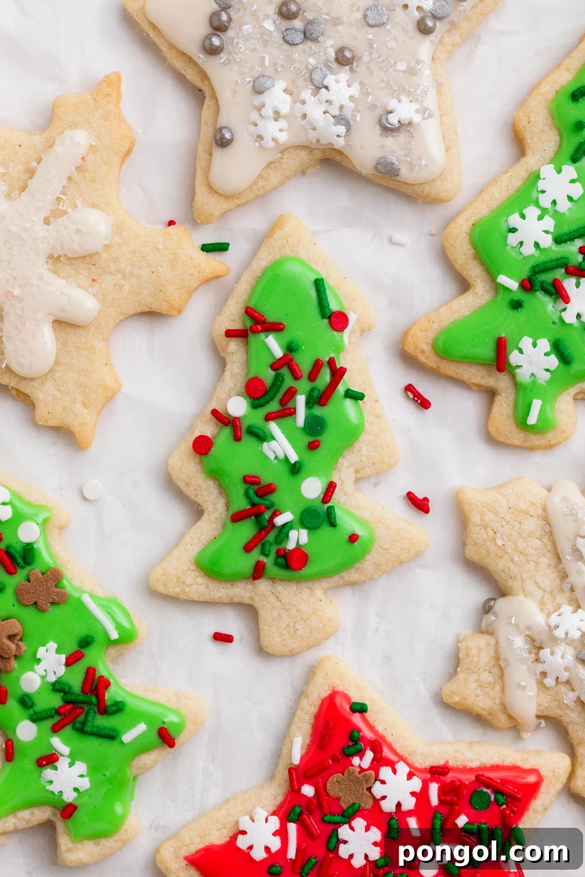 Overhead view of decorated gluten-free Christmas cookies, with a green tree-shaped cookie front and center.