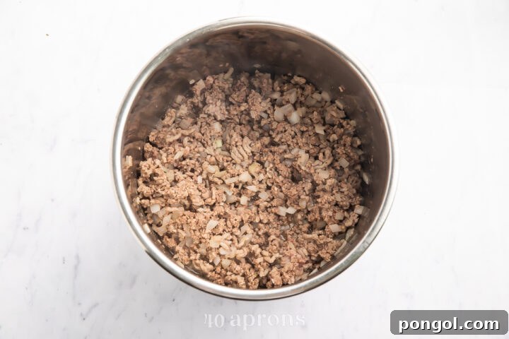 Overhead view of ground beef and Italian sausage in the Instant Pot.