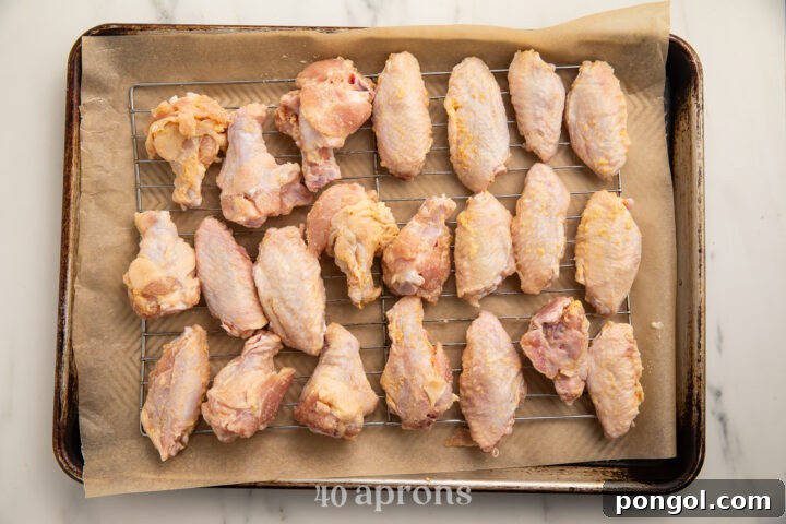 "Breaded" Whole30 chicken wings on a baking sheet lined with parchment paper.