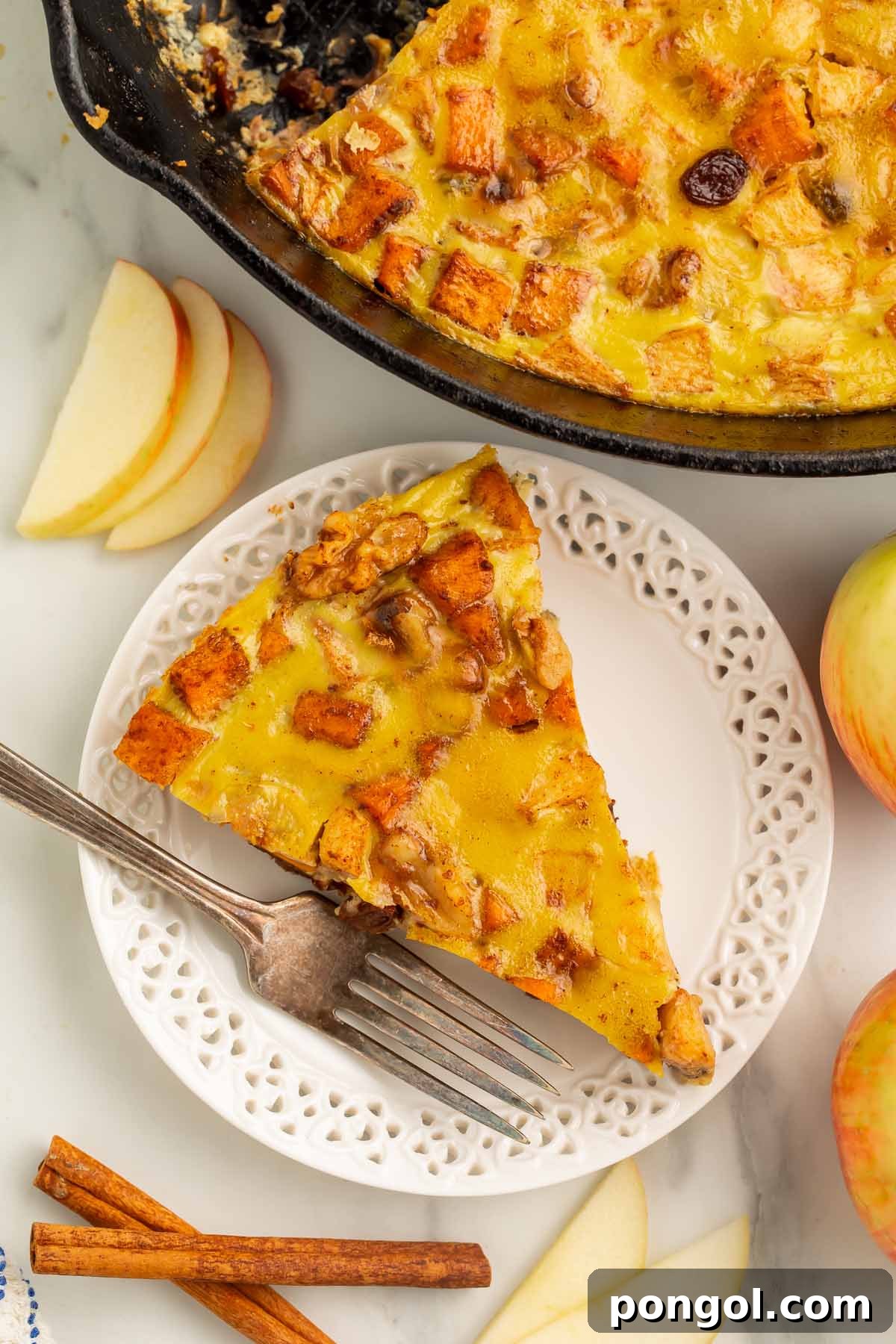 Paleo Harvest Breakfast Bake with Sweet Potatoes and Apples 4 A triangular wedge of paleo breakfast bake on a small white plate with a fork.