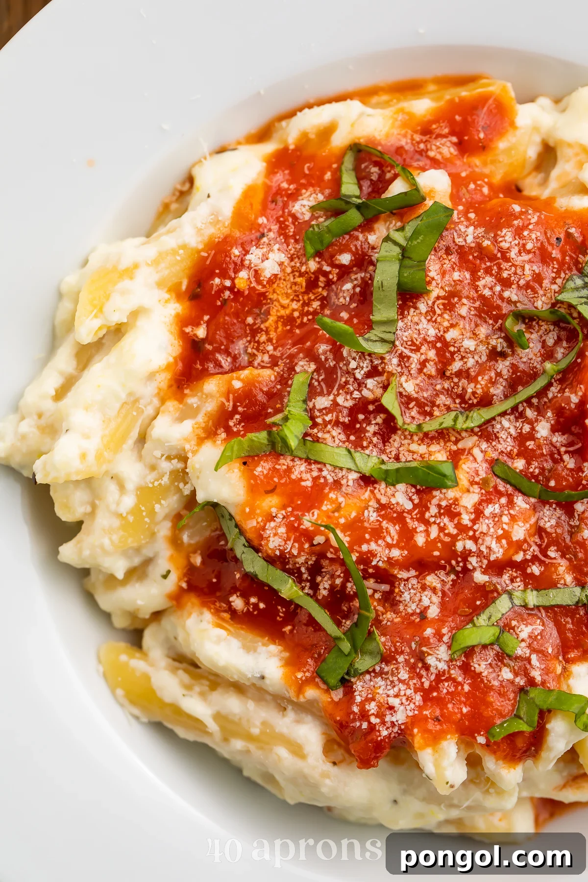 Close-up view of lemon ricotta pasta with marinara and parmesan.