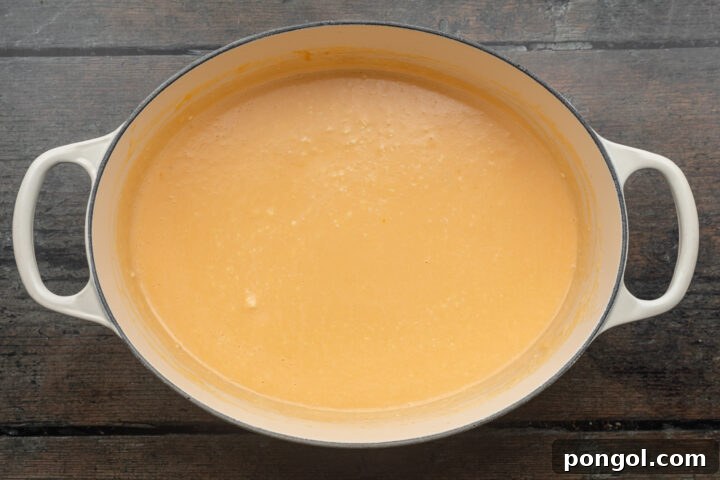 Overhead view of keto mac and cheese sauce in a large, heavy-bottomed pot, showing the creamy texture.