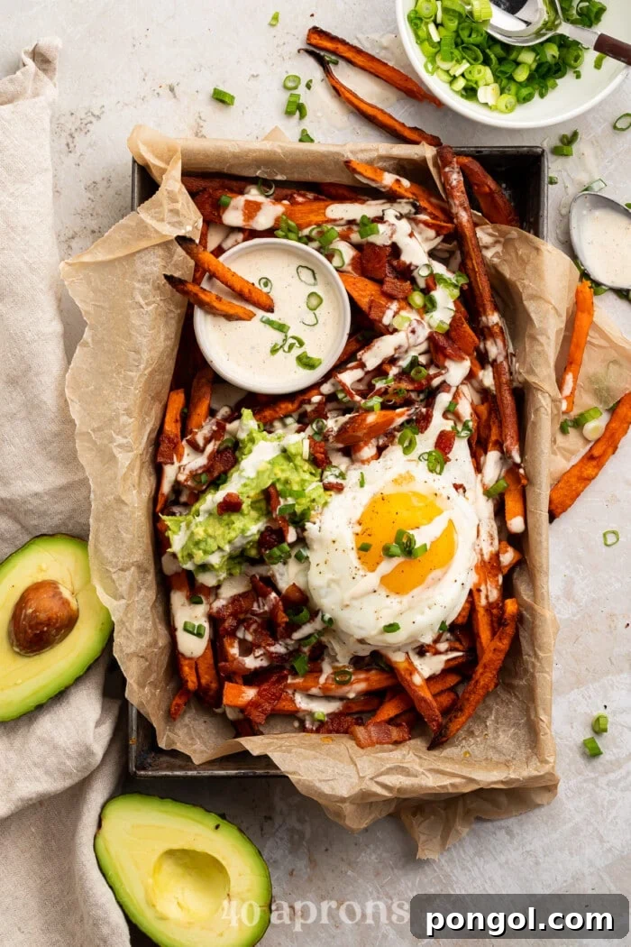 Whole30 Loaded Sweet Potato Fries in a parchment paper lined dish, shot from overhead