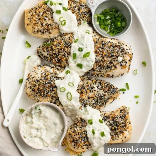 Whole30 Everything Bagel chicken with a dairy-free scallion "cream cheese" sauce on a white oval platter.