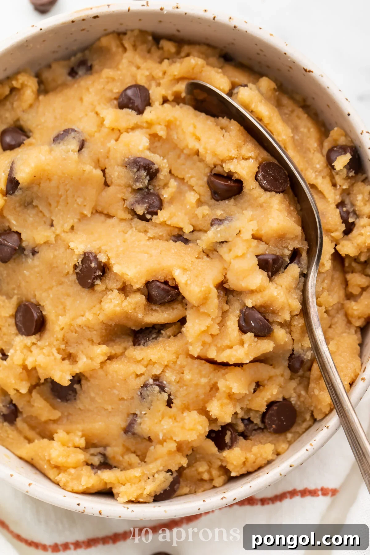 Overhead view of keto cookie dough in a large bowl with a large spoon, ready to be enjoyed as a low-carb treat.