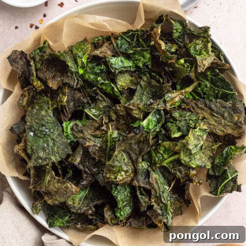 The Ultimate Air Fryer Kale Crunch 4 Overhead, zoomed out photo showing a top-down view of a large bowl of deep green air fryer kale chips.