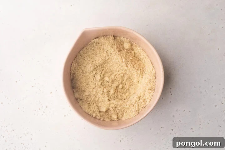 Dry ingredients for keto taco tortillas in a large mixing bowl, clearly showing almond flour and psyllium husk.