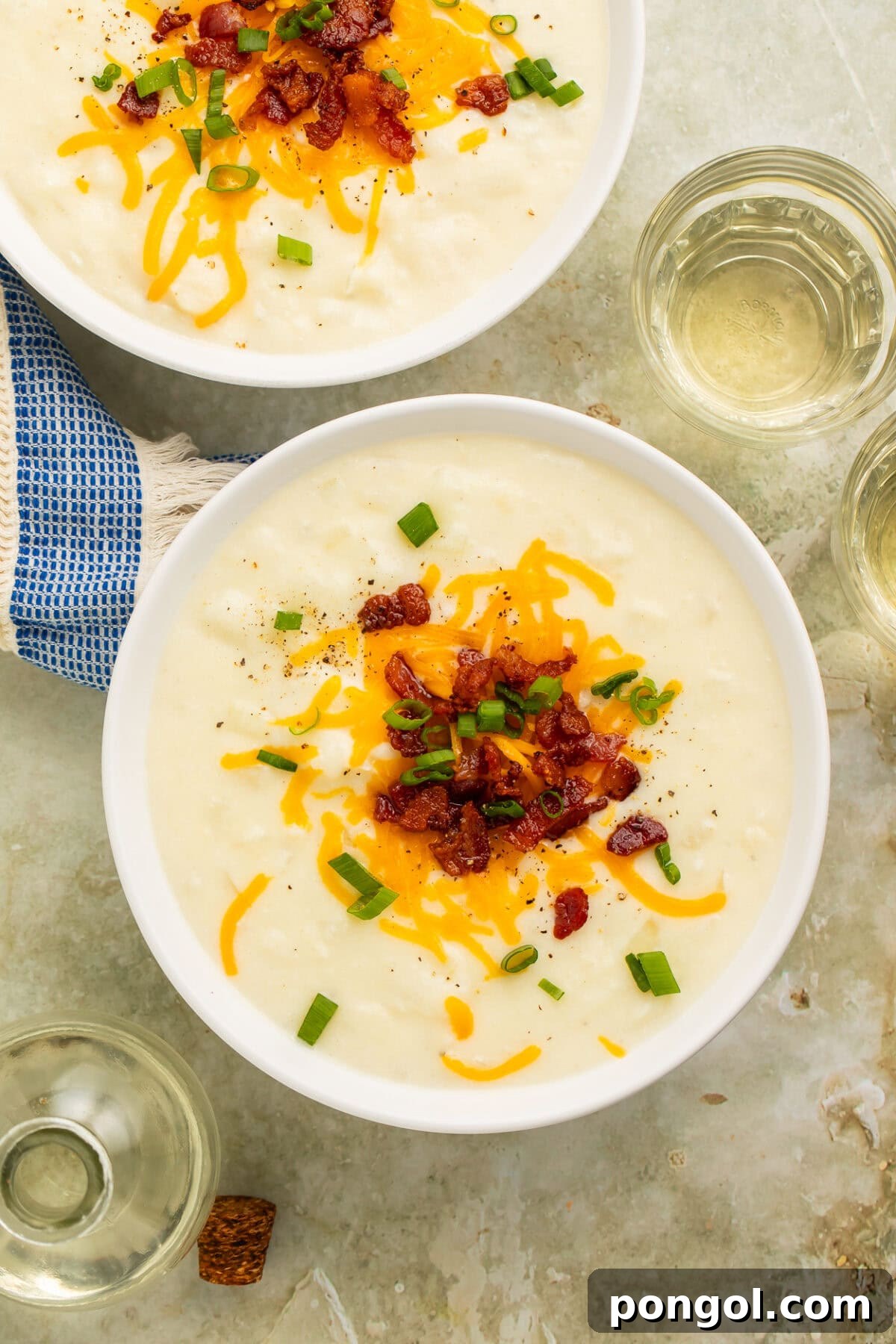 Creamy Country Potato Soup 3 A spoon lifting a perfect bite of loaded potato soup, showcasing its creamy texture, gooey melted cheese, and crispy bacon bits, ready to be enjoyed.