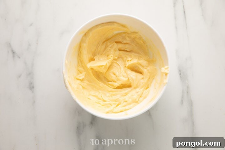 Mixing softened butter, minced garlic, garlic powder, and salt in a small bowl.