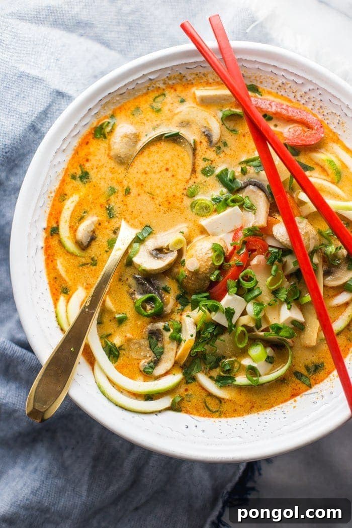 Paleo Coconut Curry Zoodle Soup, rich with creamy coconut milk, spicy red curry paste, and healthy zucchini noodles. A perfect low-carb paleo dinner that can also be made vegan.
