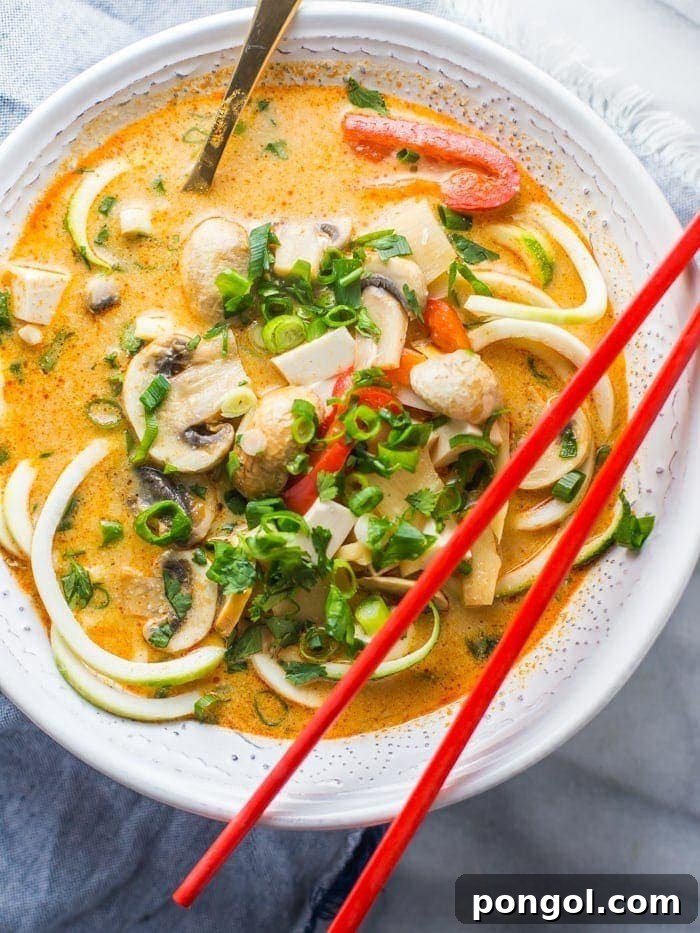 Creamy Paleo Coconut Curry Zoodle Soup with fresh herbs, a healthy and quick dinner idea. Adaptable for vegan and low-carb diets.