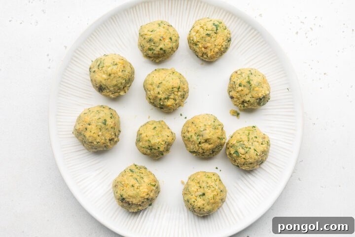 Golden Crispy Air Fryer Falafel 5 Uncooked falafel rolled into balls and placed on a white plate.
