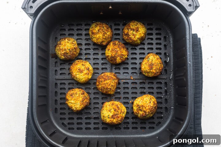 Golden Crispy Air Fryer Falafel 6 Crisp, golden brown air fryer falafel in an air fryer basket.