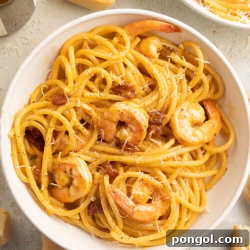 Top-down, overhead view of a large white pasta bowl filled with shrimp carbonara.