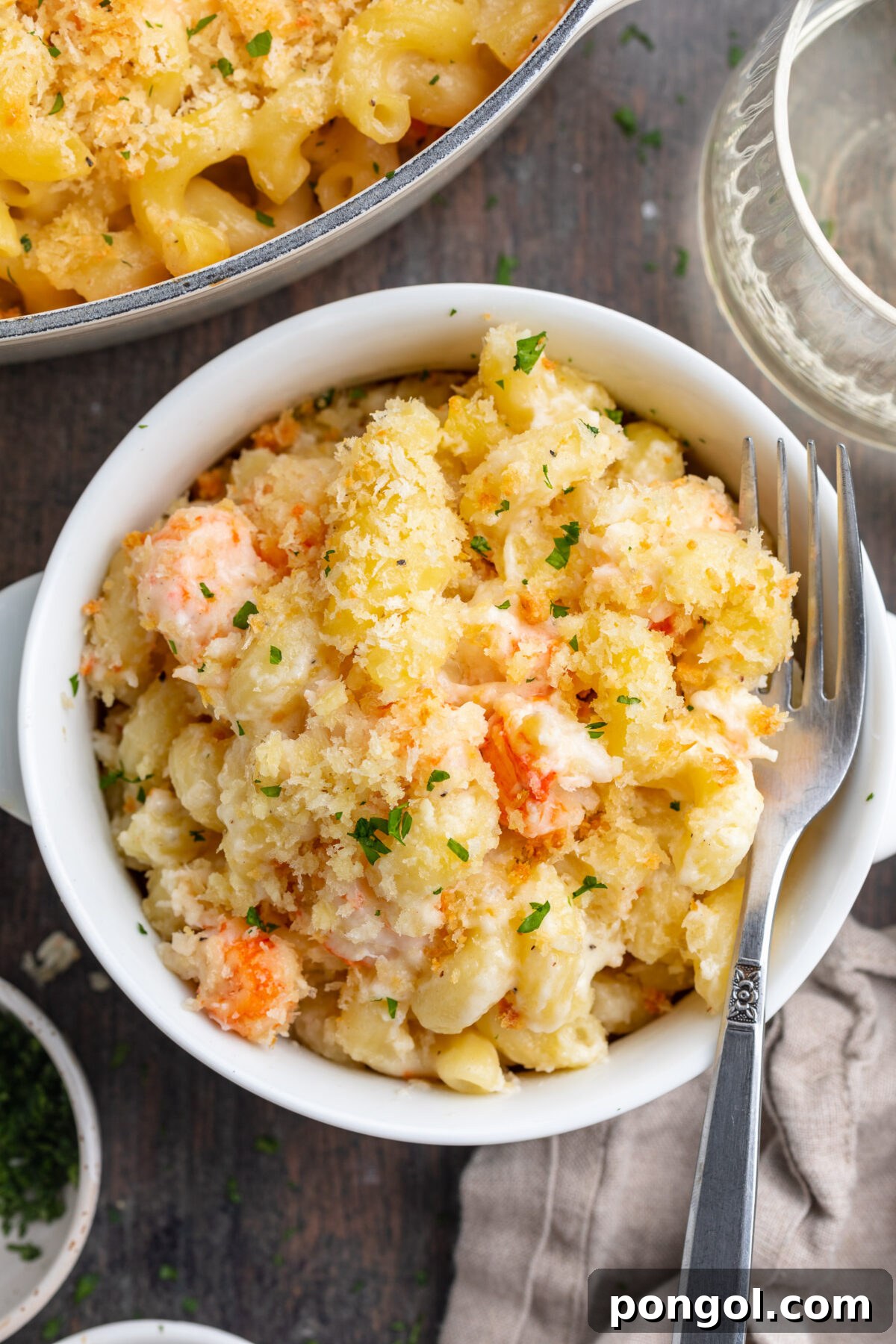 Decadent Lobster Mac 2 Overhead, top-down view of a small ramekin filled with lobster mac and cheese with a crumb topping.