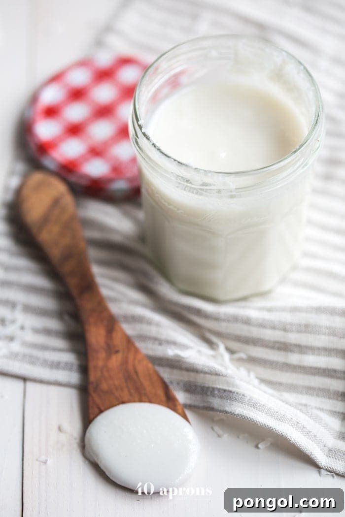A close-up shot of creamy, homemade coconut butter in a jar, highlighting its smooth texture and pristine white color. Perfect for a paleo or vegan diet.