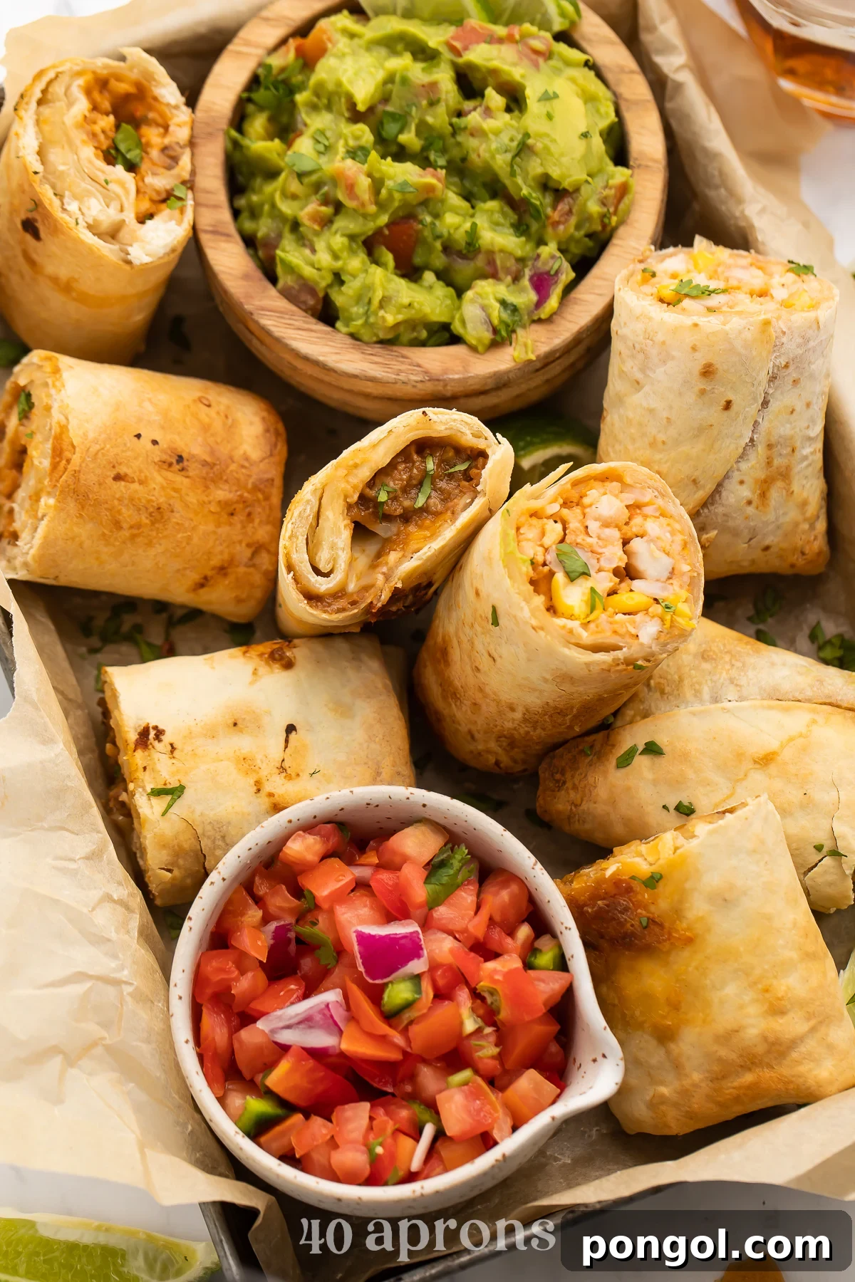 Top-down look at a dark silver baking pan, angled from top left corner to bottom right corner, holding air fryer frozen burritos with guac and pico de gallo.